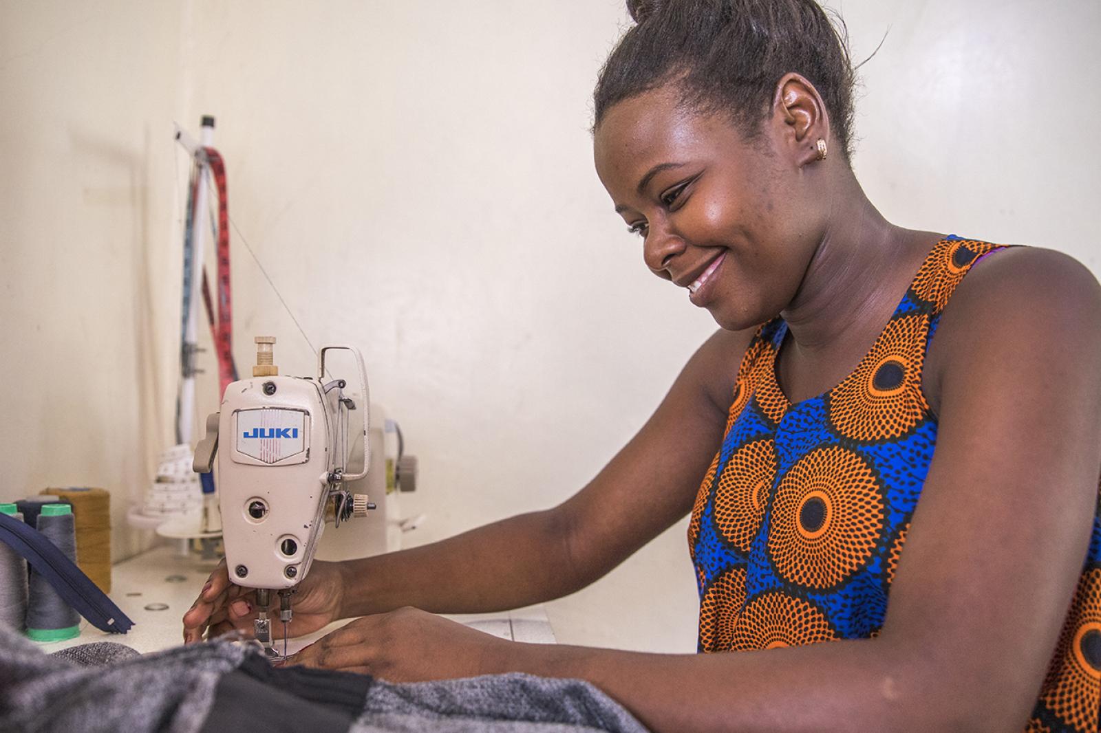 Young woman at sewing machine.