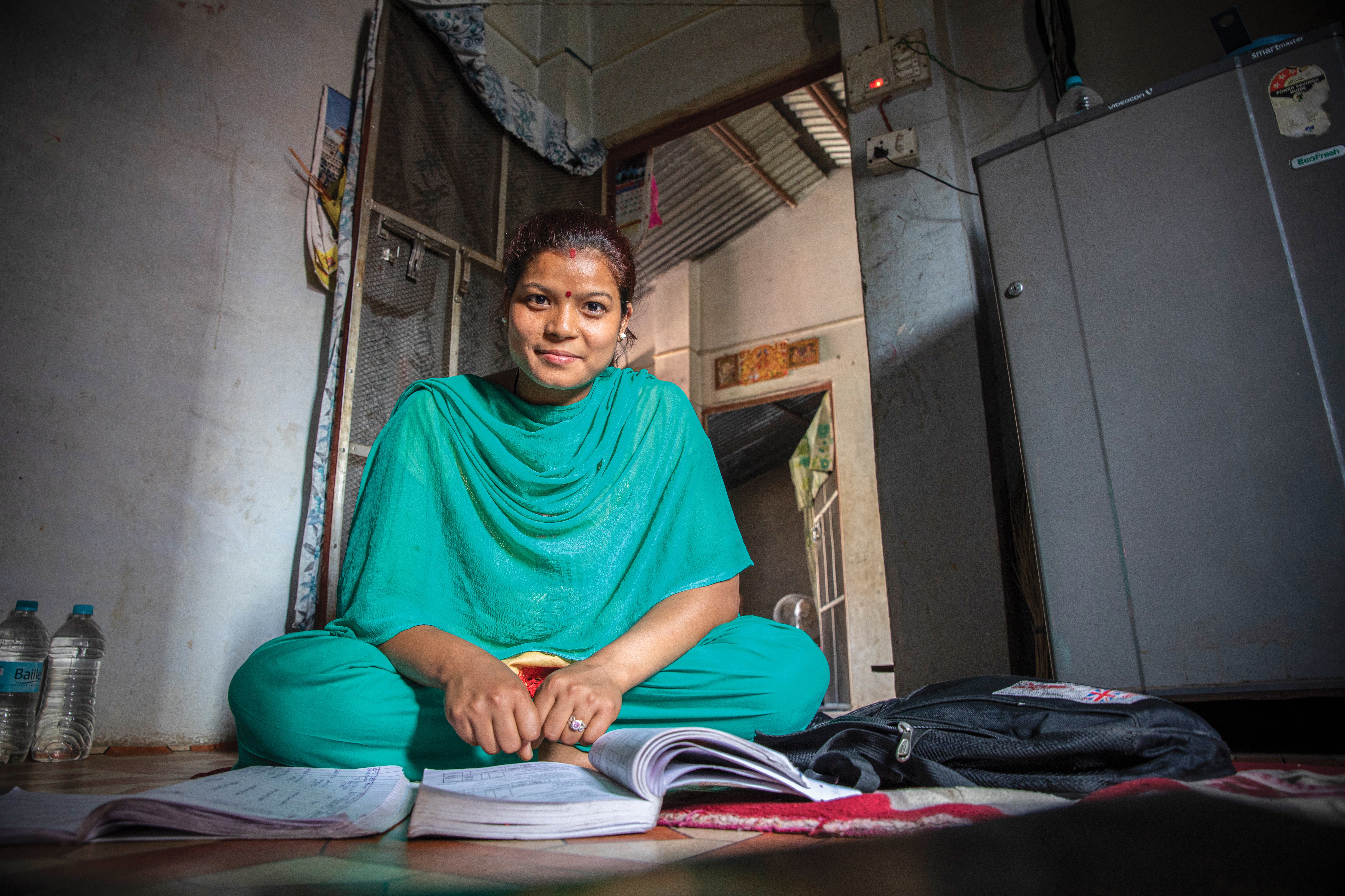 Young woman sitting cross-legged on floor.