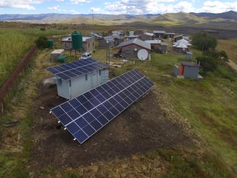 overhead view of solar panels on houses in small village